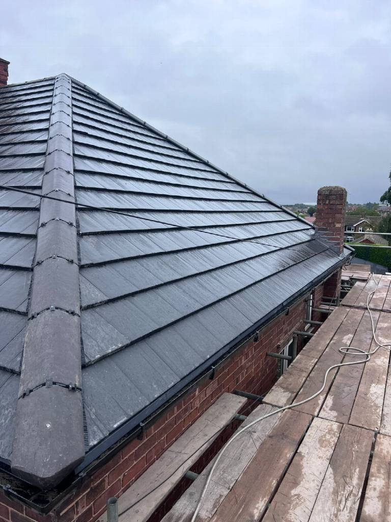 After: finished grey concrete tile roof in Worksop with dry ridge system and new black guttering
